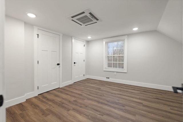 additional living space with dark hardwood / wood-style floors and vaulted ceiling