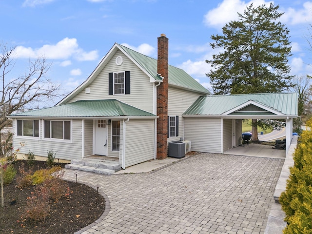 view of front of property featuring central AC unit and a carport