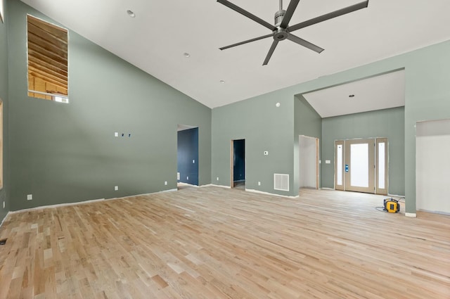 unfurnished living room with high vaulted ceiling, ceiling fan, and light wood-type flooring