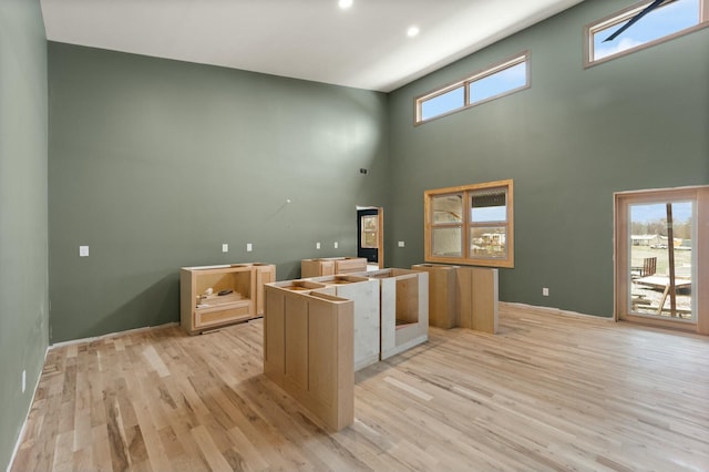 kitchen featuring a center island, a towering ceiling, and light hardwood / wood-style floors