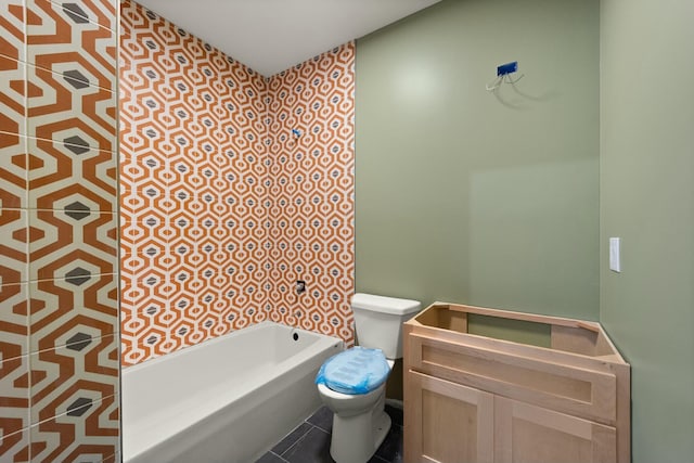 bathroom featuring toilet, tile patterned floors, a bath, and vanity