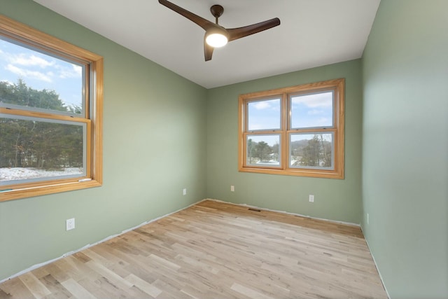 unfurnished room featuring ceiling fan, a healthy amount of sunlight, and light hardwood / wood-style floors