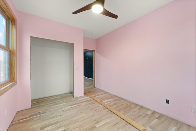 unfurnished bedroom featuring ceiling fan, light wood-type flooring, and a closet