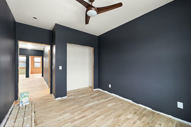 empty room with ceiling fan and light hardwood / wood-style flooring