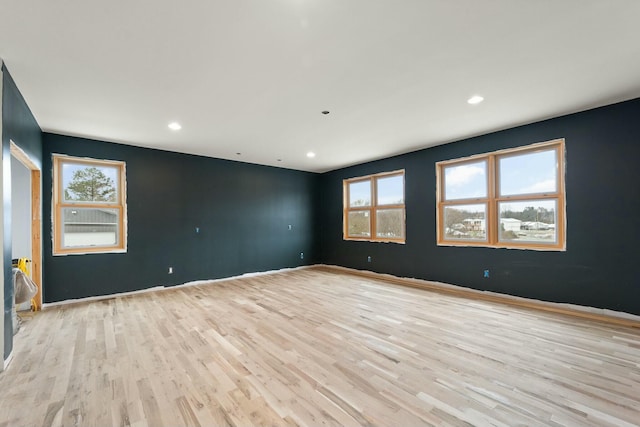 empty room with light hardwood / wood-style flooring and a healthy amount of sunlight