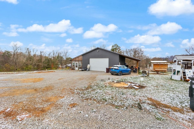 view of side of property with a carport, an outdoor structure, and a garage