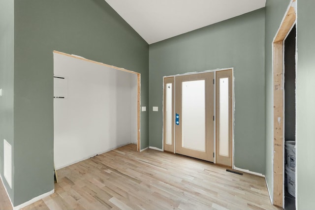 foyer entrance featuring a high ceiling, light hardwood / wood-style flooring, and plenty of natural light