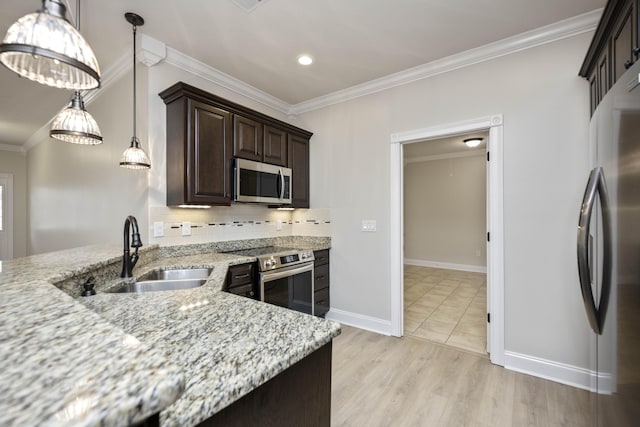 kitchen with hanging light fixtures, sink, appliances with stainless steel finishes, light stone counters, and dark brown cabinetry