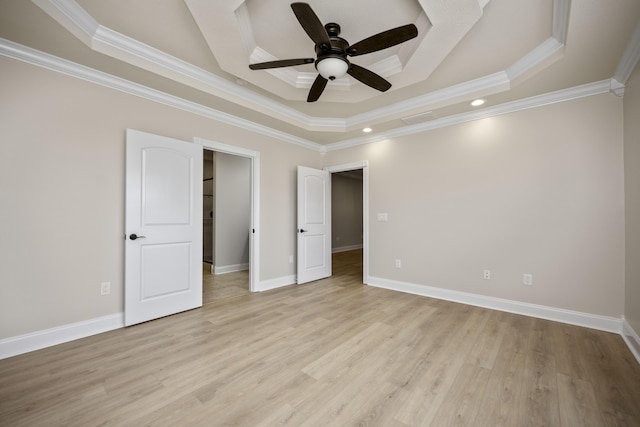 unfurnished bedroom with ceiling fan, light wood-type flooring, crown molding, and a tray ceiling