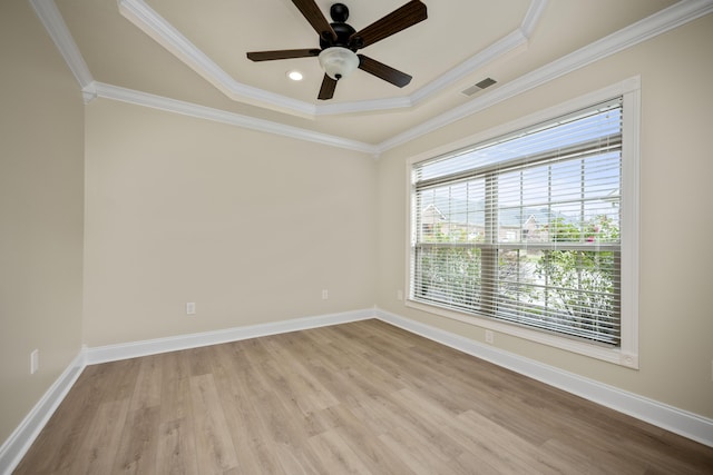 unfurnished room featuring a tray ceiling, crown molding, light hardwood / wood-style flooring, and ceiling fan