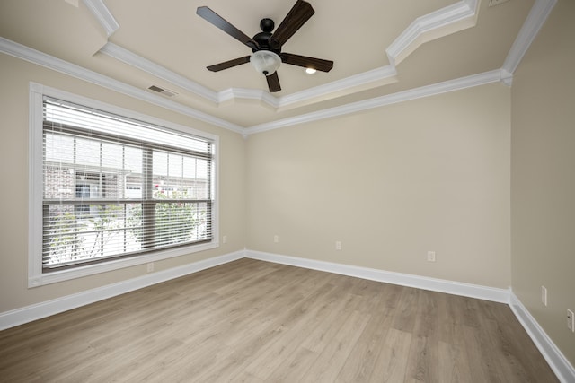 unfurnished room featuring a tray ceiling, light hardwood / wood-style flooring, ceiling fan, and ornamental molding