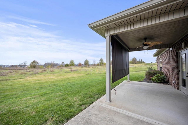 view of yard with ceiling fan, a rural view, and a patio area