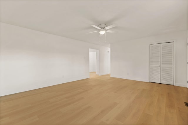 empty room with ceiling fan and light hardwood / wood-style floors