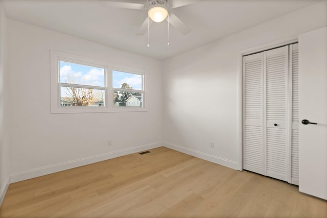 unfurnished bedroom featuring a closet, light hardwood / wood-style flooring, and ceiling fan