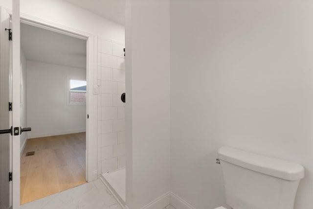 bathroom featuring wood-type flooring, toilet, and walk in shower