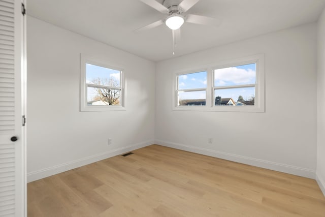 unfurnished room with plenty of natural light, ceiling fan, and light wood-type flooring