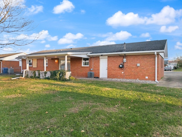 rear view of house with a lawn and central air condition unit