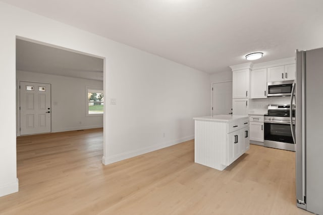 kitchen with white cabinetry, a center island, stainless steel appliances, and light hardwood / wood-style floors