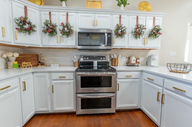 kitchen featuring backsplash, white cabinetry, dark wood-type flooring, and stainless steel appliances