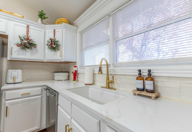 kitchen with white cabinets, decorative backsplash, and sink