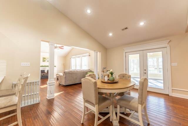 dining area featuring french doors, decorative columns, ceiling fan, dark wood-type flooring, and high vaulted ceiling