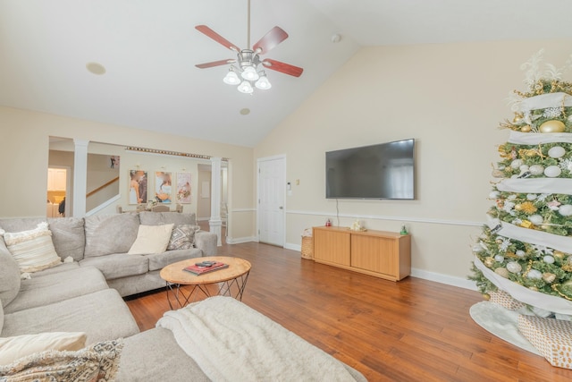 living room with decorative columns, ceiling fan, high vaulted ceiling, and dark wood-type flooring