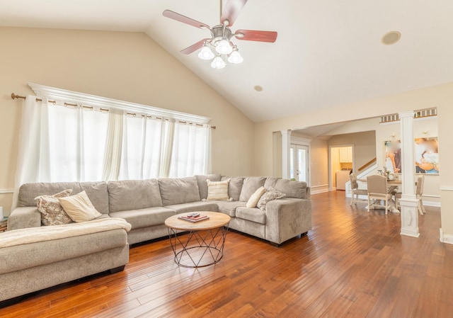 living room with decorative columns, hardwood / wood-style flooring, and a healthy amount of sunlight