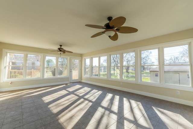 unfurnished sunroom featuring ceiling fan and a healthy amount of sunlight