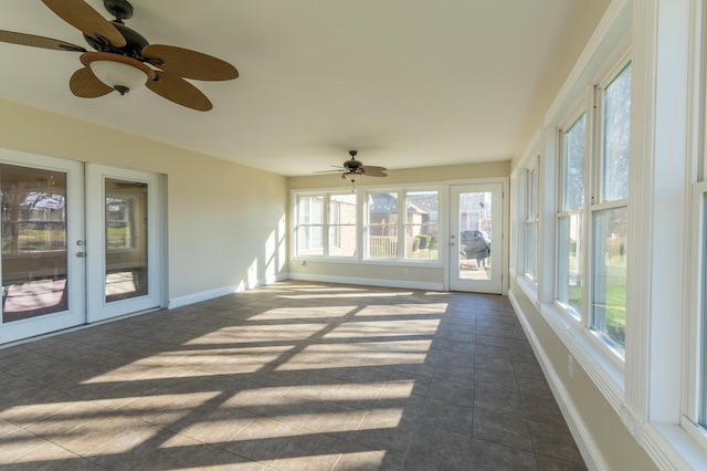 unfurnished sunroom featuring ceiling fan