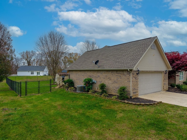 view of side of property featuring a garage, a yard, and central air condition unit