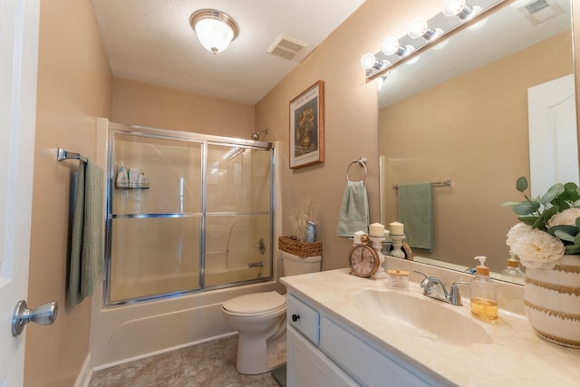 full bathroom featuring a textured ceiling, vanity, toilet, and bath / shower combo with glass door