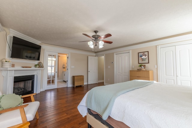 bedroom featuring a textured ceiling, dark hardwood / wood-style flooring, ceiling fan, and crown molding