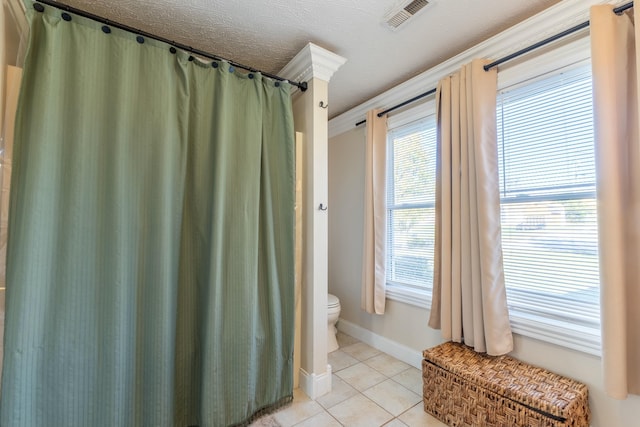 bathroom with tile patterned floors, toilet, and a textured ceiling