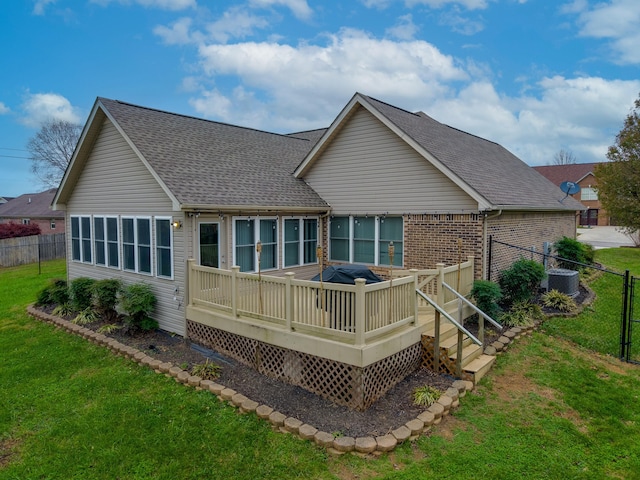 rear view of house with central air condition unit, a wooden deck, and a yard