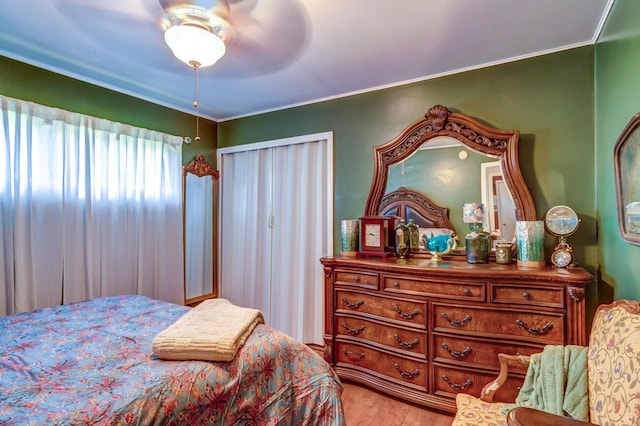 bedroom with crown molding, wood-type flooring, and ceiling fan