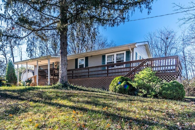 back of property featuring a wooden deck and a yard