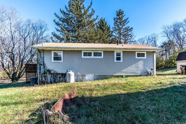 view of side of home featuring a yard and central AC