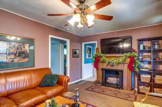 living room featuring ornamental molding, carpet floors, ceiling fan, and a fireplace