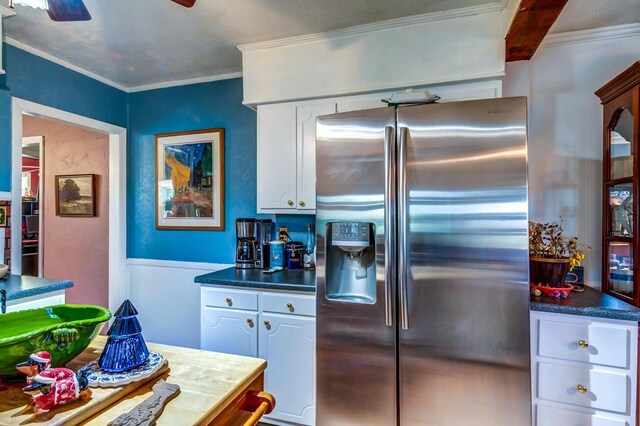 kitchen with stainless steel refrigerator with ice dispenser, ceiling fan, white cabinets, and crown molding