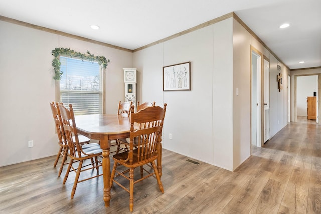 dining area featuring ornamental molding and light wood-type flooring