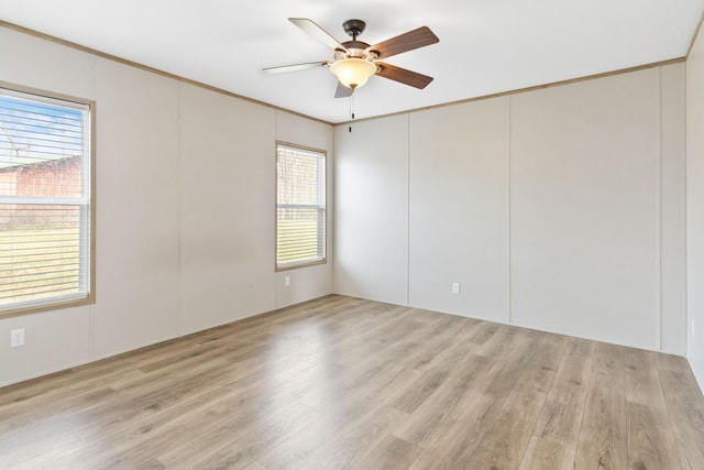 empty room with ceiling fan, a healthy amount of sunlight, and light wood-type flooring