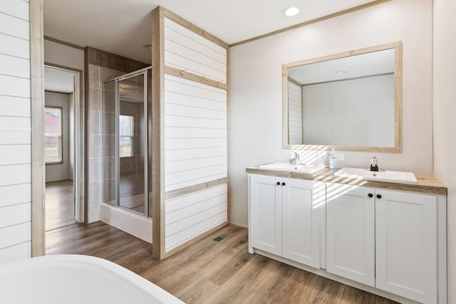 bathroom featuring walk in shower, wood-type flooring, and vanity