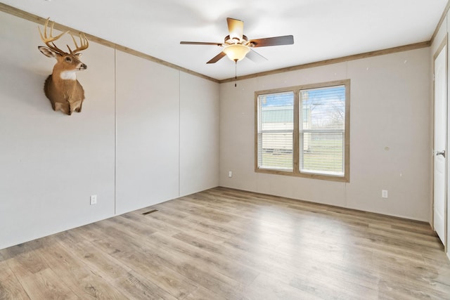 spare room with ornamental molding, ceiling fan, and light wood-type flooring