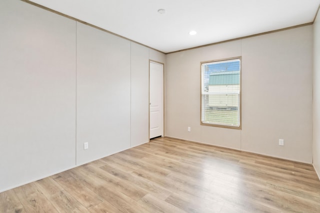 unfurnished room with crown molding and light hardwood / wood-style flooring