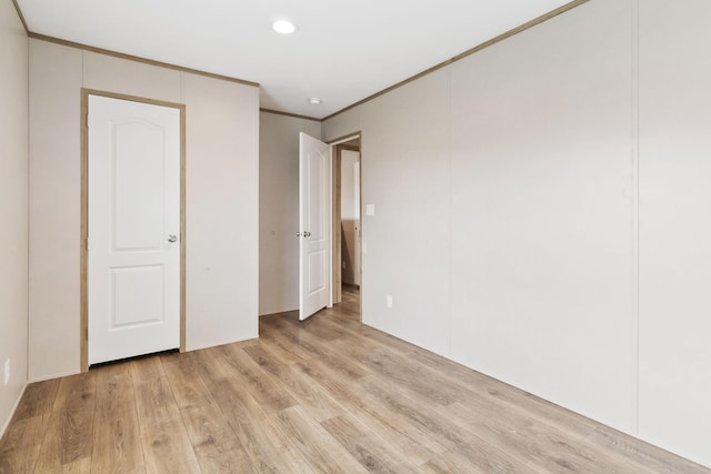 unfurnished bedroom featuring crown molding and light hardwood / wood-style floors