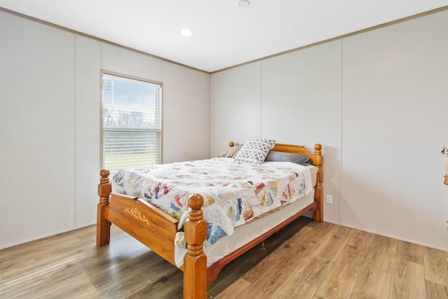 bedroom with crown molding and light hardwood / wood-style floors