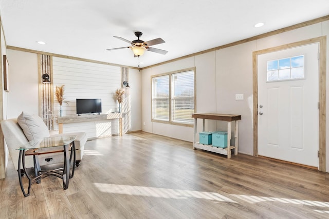 foyer entrance with ceiling fan, ornamental molding, and light hardwood / wood-style floors