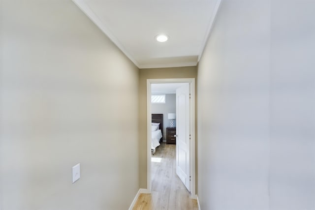 hallway with crown molding and light wood-type flooring