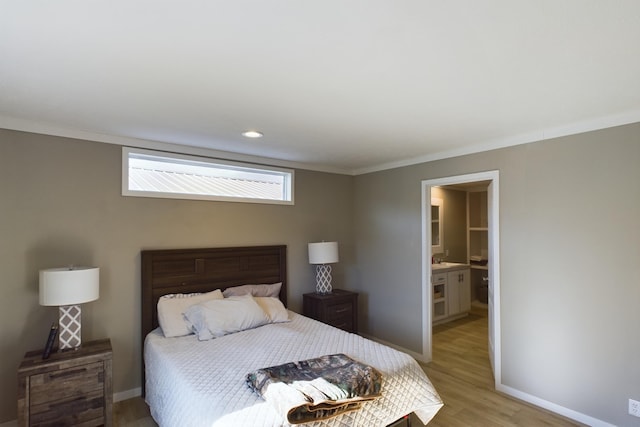 bedroom with ensuite bathroom, light hardwood / wood-style flooring, and crown molding