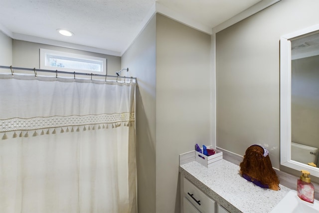 bathroom with a textured ceiling, vanity, wood-type flooring, and crown molding